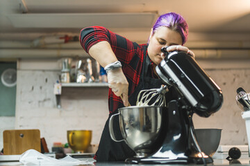 Person baking cookies. Professional pastry cook scooping out the dough out of food processor. Indoor copy space. High quality photo