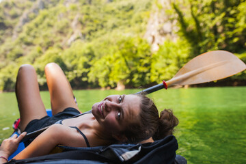 young active girl enjoying a kayak ride on a river in the mountains - obrazy, fototapety, plakaty