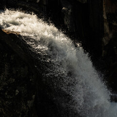 Droplets Of Water Catch Morning Light As They Tumble Over A Cliff