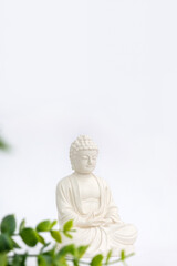 Vertical banner for Vesak Day. Happy Buddha Day with Siddhartha Gautama statue on white background. Mental health and meditation concept. Selective soft focus.
