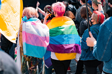 Back view of people with LGBT and Trans flags protest on the street. Equality. Freedom. Protest....