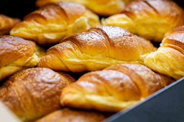 Selective focus on a croissant in a box full of pastries