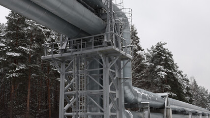 pipeline,pictured pipeline in winter against the background of a snow-covered forest and gray sky