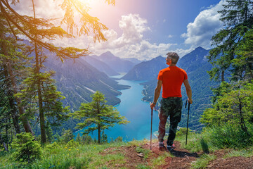 Hiker in the Alps. Backpacker tourist hiking at Lake. - 558253734