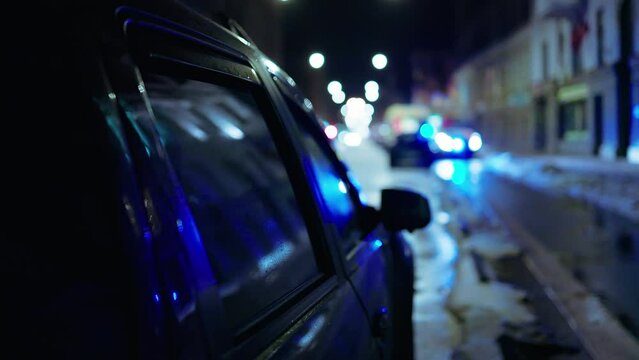 Defocused: Ambulance with flashing siren lights at city street