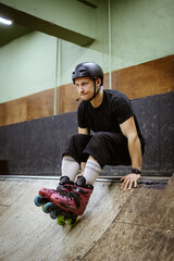 Athletic roller skater in helmet training on ramp 