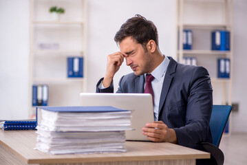 Naklejka premium Young male employee working in the office