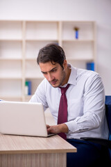 Young male employee and too much work in the office