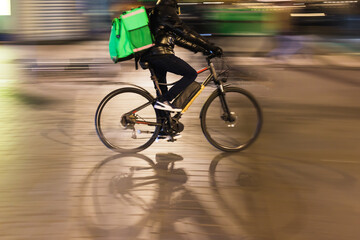 bicycle rider on a city street at night