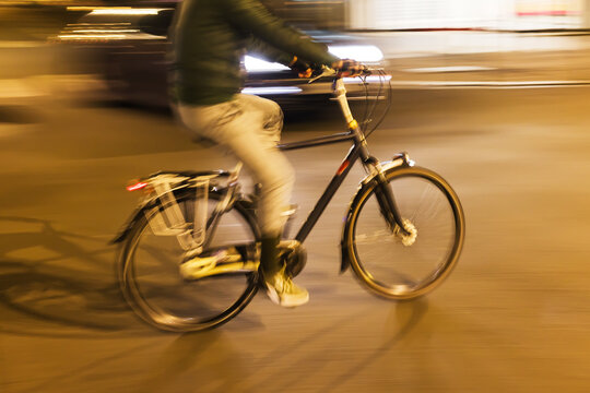 bicycle rider on a city street at night