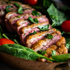 Pan-roasted duck breast served with spinach, arugula, and grape tomatoes. Garnished with parsley and black poppy seeds.