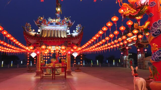 Panning shot, 4K, A quiet Chinese temple at night with lanterns hung throughout the courtyard in preparation for the upcoming Chinese New Year.
