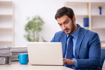 Fototapeta premium Young male employee and too much work in the office