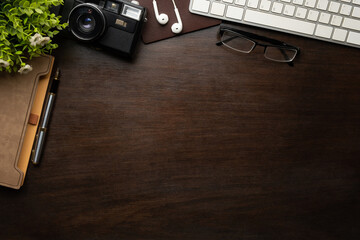 Hipster workspace with retro camera,glasses and notebook on wooden table. Top view with copy space for your text.