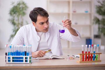 Young male chemist working at the lab