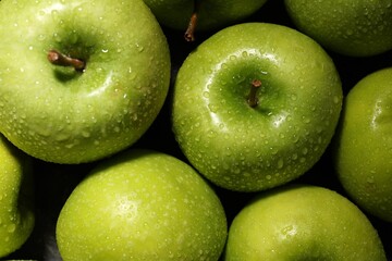 Ripe green apples with water drops as background, top view