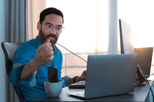 Crazy man office work. Work stress. Throwing the mouse in the coffee cup