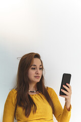 woman in yellow shirt on white background talking on mobile phone