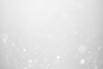 White glitter vintage lights background.  White bokeh shiny on dark background.