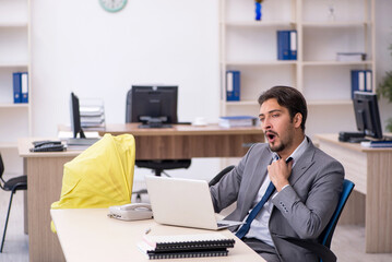Young male employee looking after new born at workplace