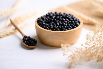 Fototapeta na wymiar Black soybean seeds in bowl with spoon, food ingredients high protein good for vegetarian and vegan