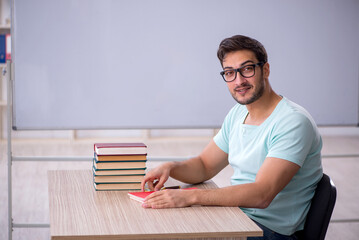 Young male student preparing for exams in the classroom