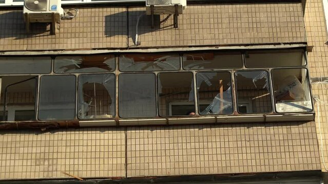 Consequences of rocket attack on the center of Ukraine. Funnel from a drone explosion. Attack of Iranian Shahed 136 drones on Kyiv. Damaged residential building. Broken windows and holes from debris. 