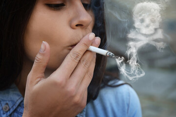 Fototapeta premium No Smoking. Woman with cigarette outdoors, closeup. Skull and crossbones symbol of smoke