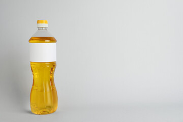 Bottle of cooking oil on light grey background. Space for text