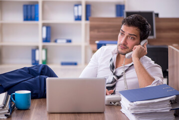 Obraz premium Young male employee unhappy with excessive work at workplace