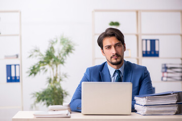 Fototapeta premium Young male employee and too much work in the office