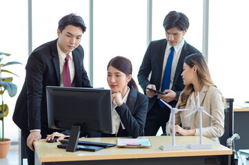 Millennial Asian young professional successful  businesswoman in formal suit with female and male businessman colleague in formal suit brainstorming  in company office room.