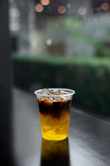 ice coffee in plastic glass on black table at cafe​