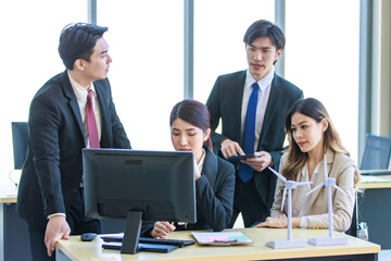 Millennial Asian young professional successful  businesswoman in formal suit with female and male businessman colleague in formal suit brainstorming  in company office room.