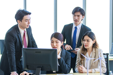 Millennial Asian young professional successful  businesswoman in formal suit with female and male businessman colleague in formal suit brainstorming  in company office room.