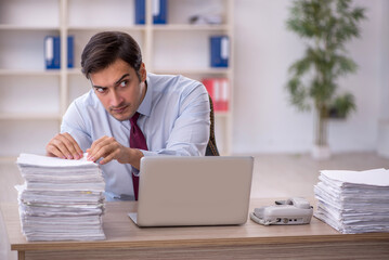 Young male employee and too much work in the office