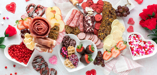 A Valentine's Day charcuterie arrangement with deli meats, cheese and sweets.