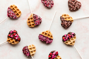 Top down view of decorated heart shaped waffle pops for Valentine's Day