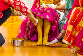 Indian Hindu bride's pre wedding haldi yellow turmeric ceremony fet close up