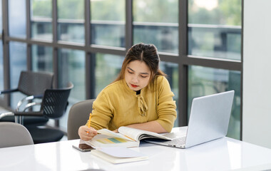 portrait of Asian female student studying at university library