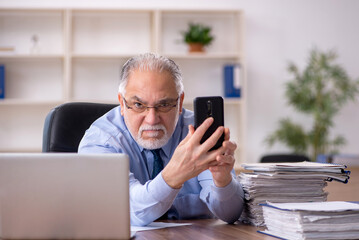 Old male employee working in the office