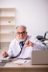 Old male doctor working in the clinic