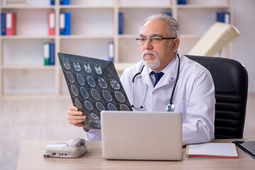 Old male doctor radiologist working in the clinic