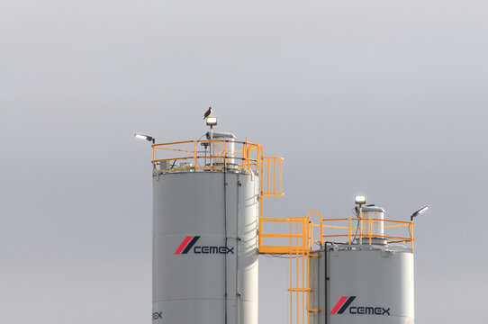 Twin Cemex silos with safety railings and access platforms, illustrating industrial storage infrastructure for cement manufacturing and bulk construction materials handling