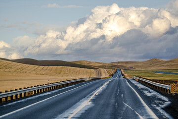 Lost in the hills of the highway road disappears into the horizon among fields with neatly mowed grass in the state of Washington