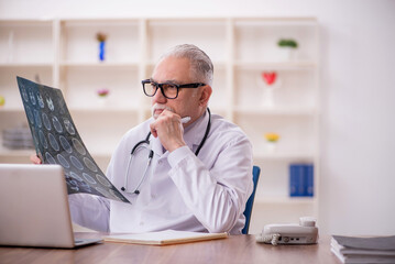 Old male doctor radiologist working in the clinic