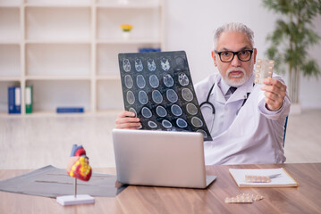 Old male doctor radiologist working in the clinic