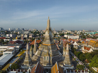 Fototapeta premium An aerial view of the Pagoda stands prominently at Wat Arun Temple with Chao Phraya River, The most famous tourist attraction in Bangkok, Thailand.