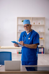 Old male doctor working in the clinic