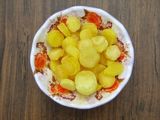 Dried pineapple sliced in a bowl on wooden background  top view 